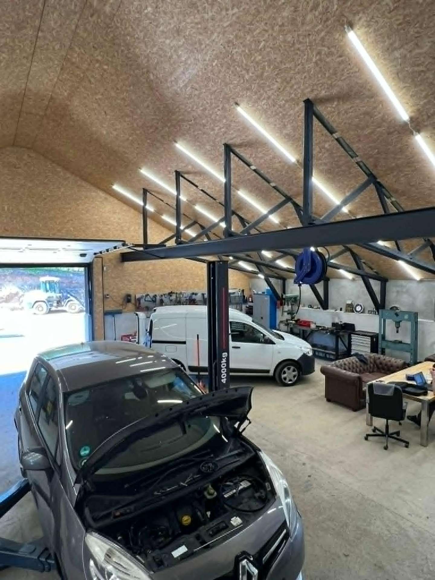 Værkstedshal med biler og lift hos Autoteknik Tebstrup